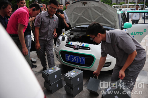 力帆汽車研發(fā)生產(chǎn)的電動汽車，工作人員正在為車輛替換電源。
