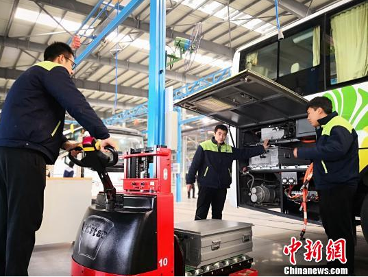 圖為工作人員在給新能源車(chē)輛安裝蓄電池。魏建軍 攝